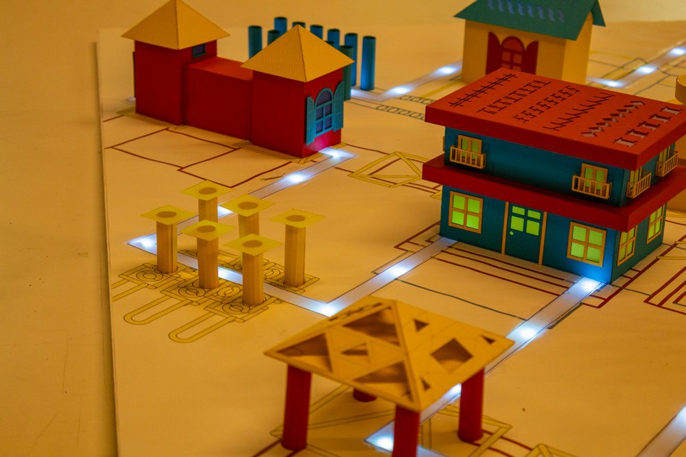 The abstraction model lit from inside, LED lights running along the paths